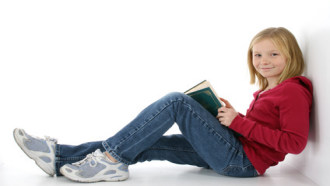 girl reading against wall